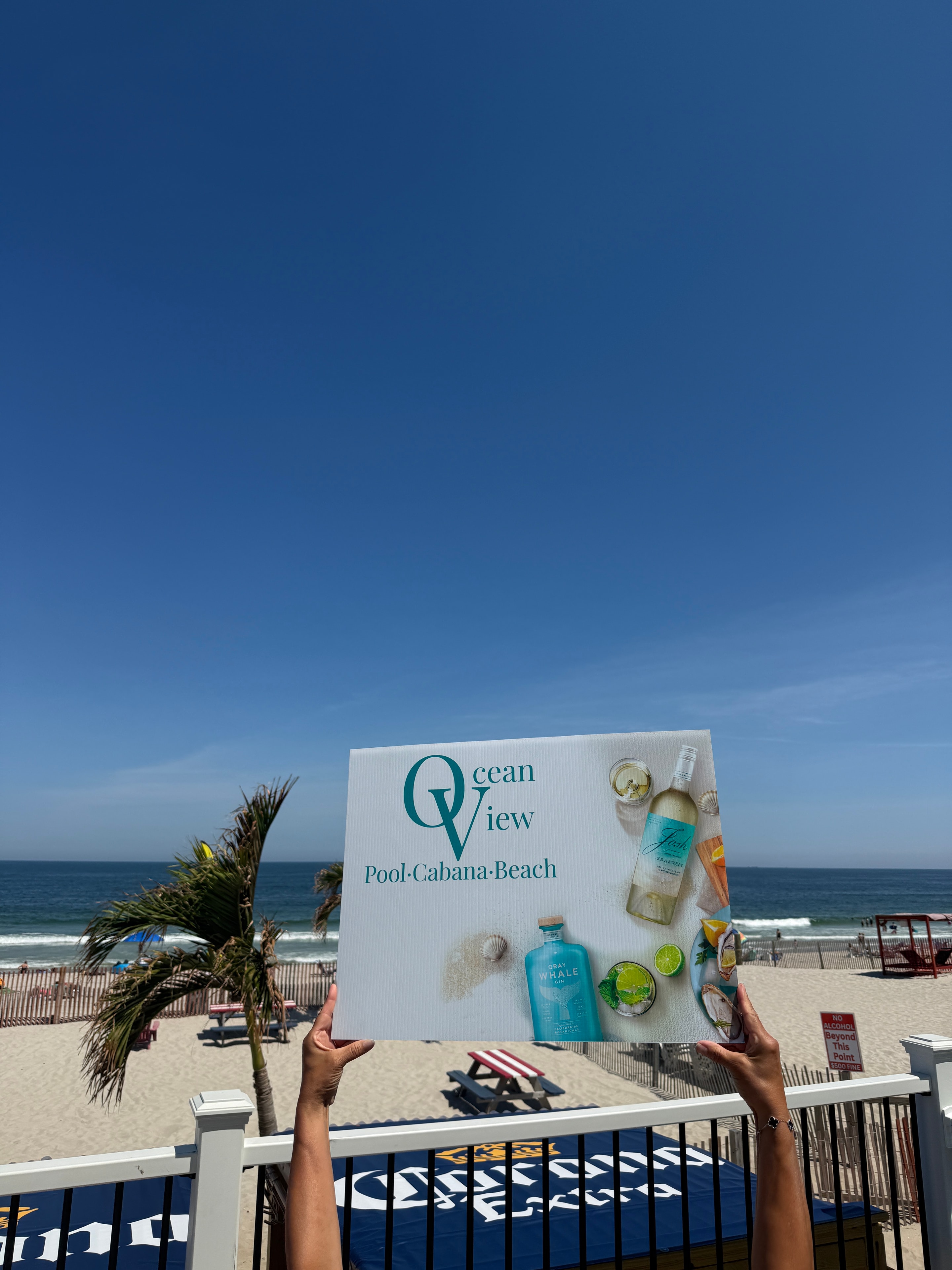 Ocean View Pool & Cabanas branded sign on the beach