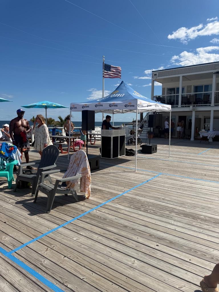 DJ performing on the boardwalk deck with ocean views