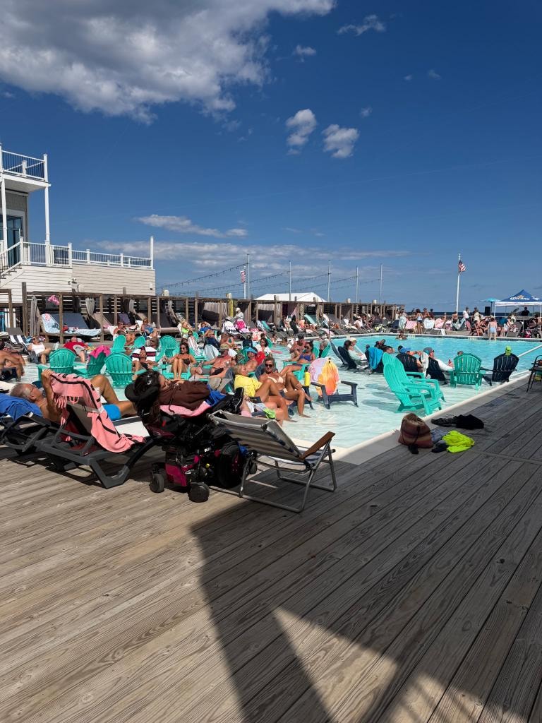 Guests relaxing at the resort pool on a sunny day